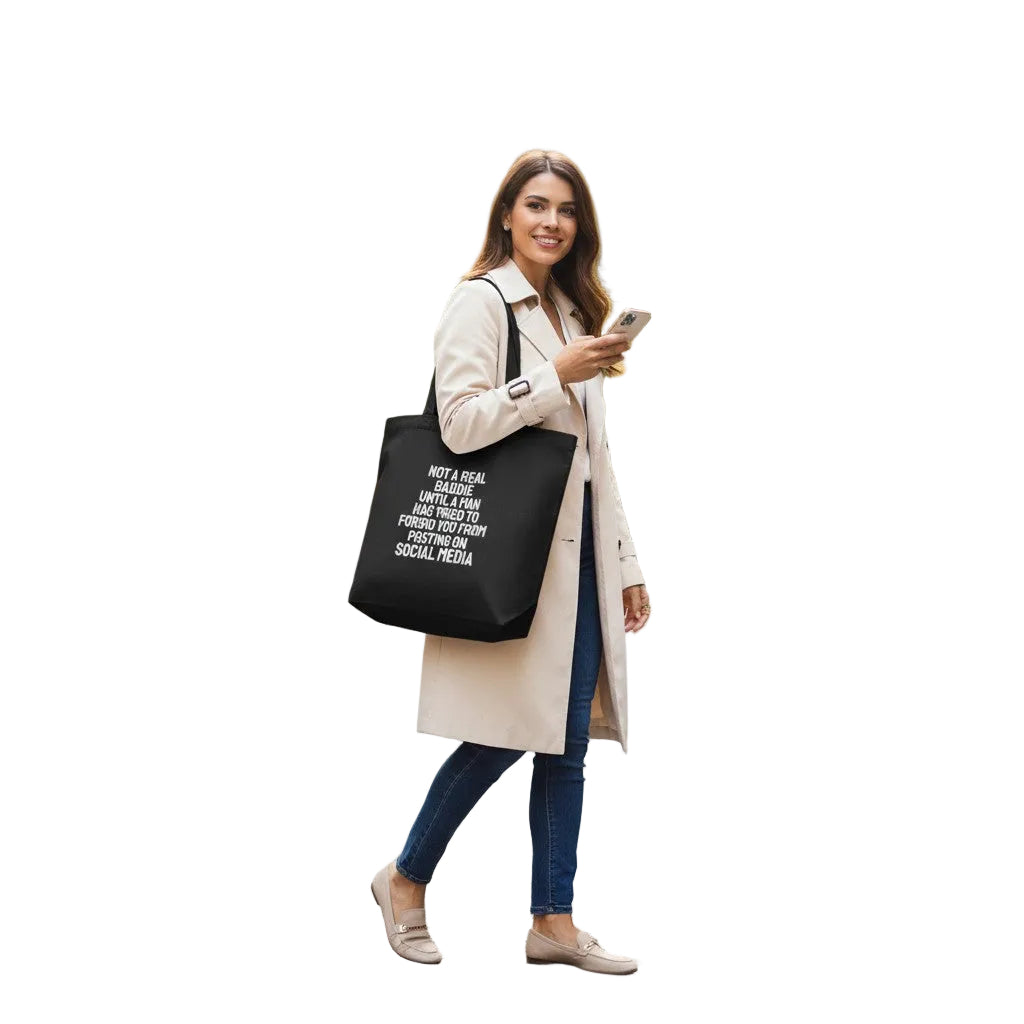 Frau trägt eine schwarze spiritualsavagee Bio-Baumwolltasche mit weißem Statement-Aufdruck in einer Stadtstraße