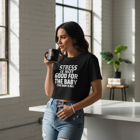 Eine Frau trägt ein schwarzes spiritualsavagee Crop Top mit weißem Aufdruck Stress is not good for the baby