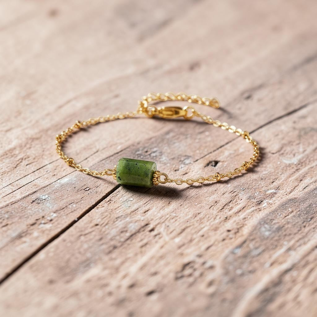 spiritualsavagee Jade Balance Armband mit grünem Naturstein und vergoldeter Kette auf einem hellen Steinpodest