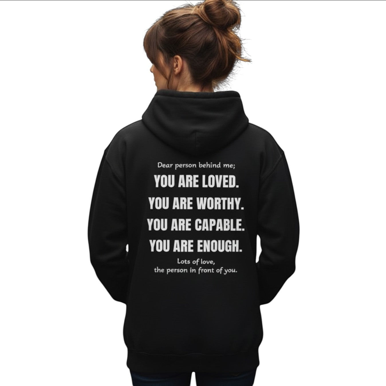 Mann trägt einen schwarzen spiritualsavagee Unisex-Hoodie mit inspirierendem Text-Aufdruck auf der Rückseite in der Stadt.
