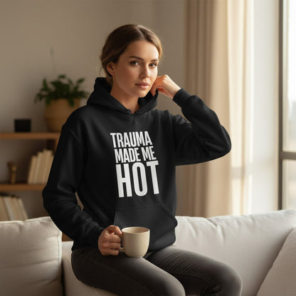 spiritualsavagee Unisex-Hoodie in Schwarz mit weißem Aufdruck Trauma Made Me Hot, getragen von einer Frau auf einem Sofa