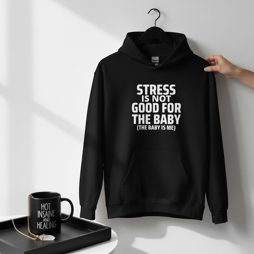 Schwarzer spiritualsavagee Unisex-Hoodie mit weißem Aufdruck Stress is not good for the baby, hängend an einem Kleiderbügel.