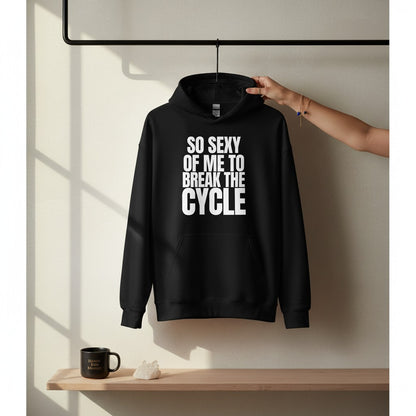 Schwarzer spiritualsavagee Unisex-Hoodie mit weißem Aufdruck So Sexy Of Me To Break The Cycle, hängend an einer Kleiderstange.
