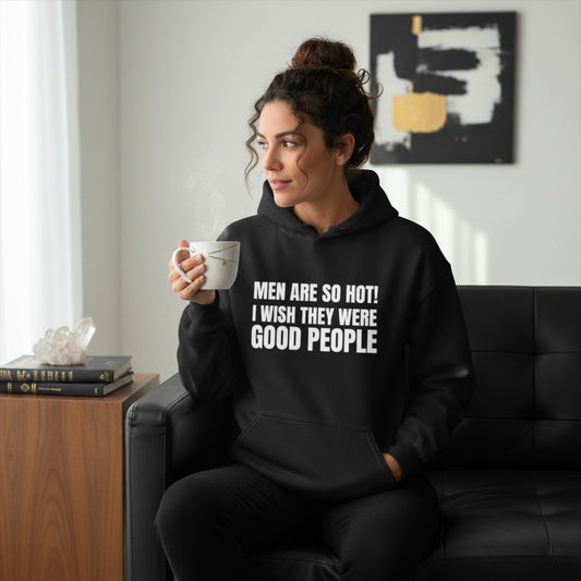 Eine Frau trägt einen schwarzen spiritualsavagee Unisex-Hoodie mit dem weißen Aufdruck Men Are So Hot I Wish They Were Good People, während sie eine Tasse Kaffee hält.