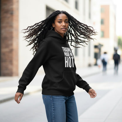 Eine Frau mit Dreadlocks trägt den schwarzen spiritualsavagee Unisex-Hoodie mit dem Aufdruck TRAUMA MADE ME HOT.