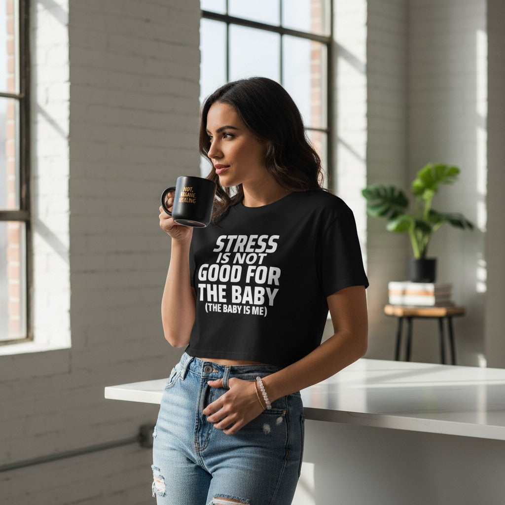 Eine Frau trägt ein schwarzes spiritualsavagee Crop Top mit weißem Aufdruck Stress is not good for the baby