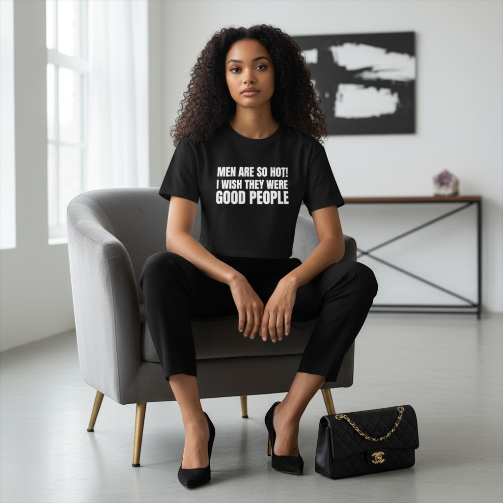 spiritualsavagee Crop-Top in Schwarz mit weißem Schriftzug, getragen von einer Frau in einem modernen Sessel.