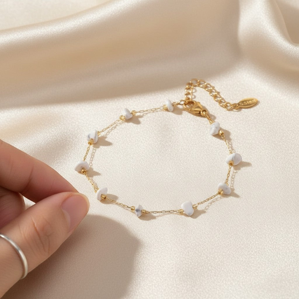 spiritualsavagee The Stillness Bracelet aus goldfarbenem Edelstahl mit zarten weißen Natursteinen auf Seidenstoff